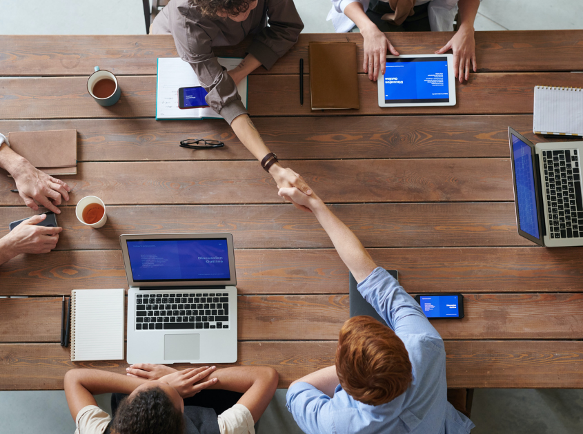 colleagues shaking hands during office meeting